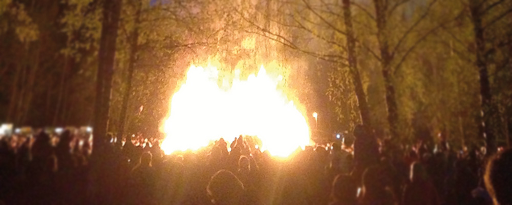 Valborgsbrasa kvällstid med massor av folk runt om kring